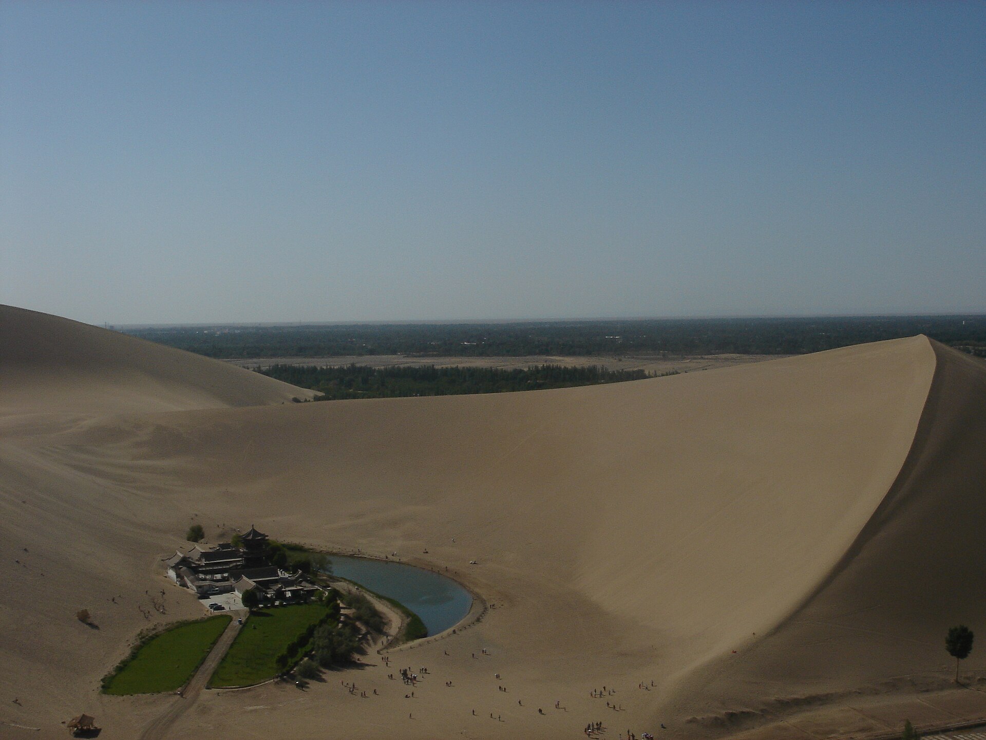 Crescent Lake and its pavilion complex sit below a high sand ridge at Mingsha Mountain near Dunhuang.